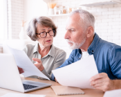 A couple over 65 reviewing their finances on paper