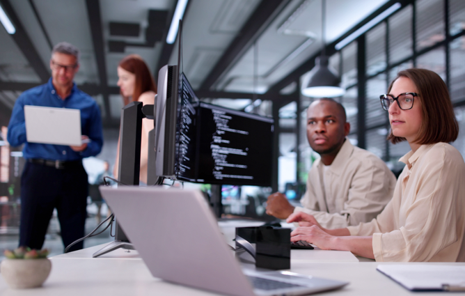 Two people monitoring information on a computer screen
